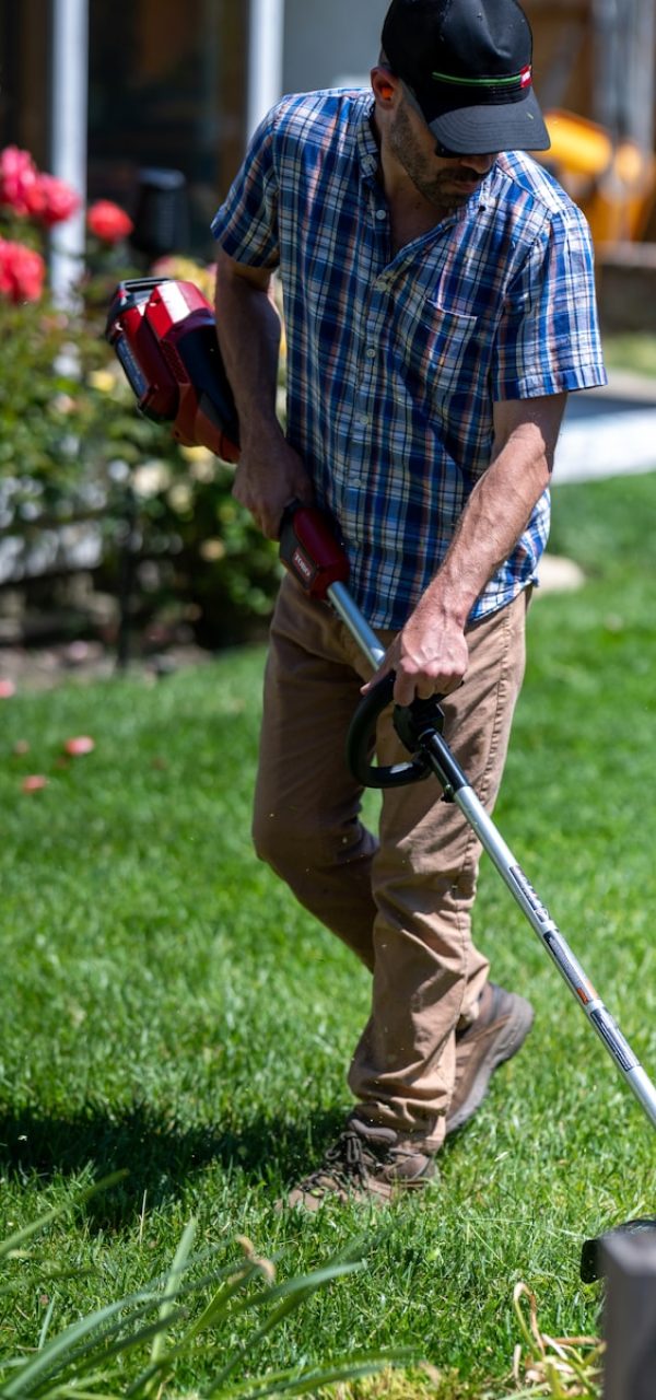 a man using a lawn mower to cut grass